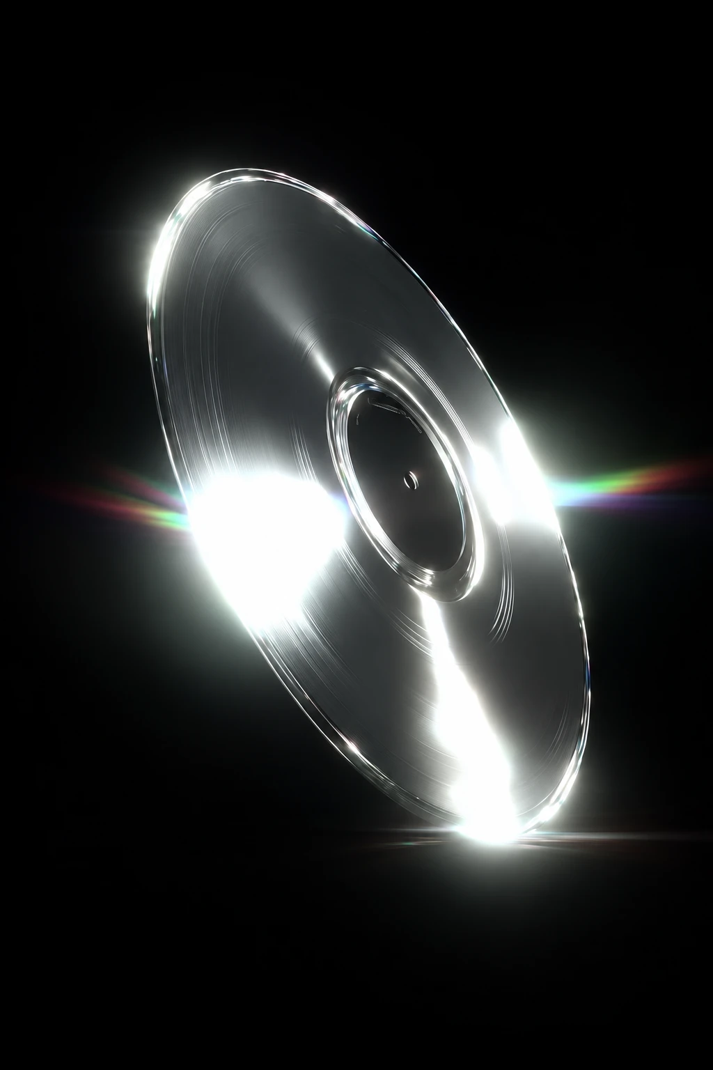 An upright mirrored silver record with brilliant white reflections and rainbow light flares on black